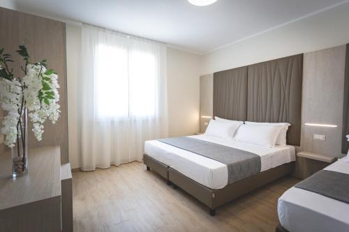 a hotel room with a bed and a window at Hotel Residence Vallecorsa in Vada