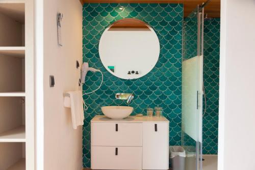 bagno con lavandino e specchio di Hotel Roca Plana a Es Pujols