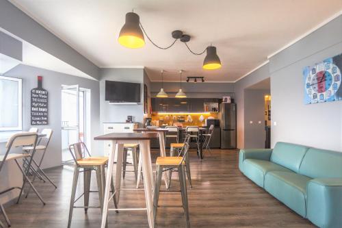 a living room with a blue couch and a kitchen at Atlantic Home Azores in Ponta Delgada