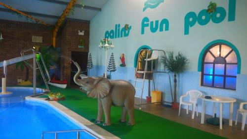 a room with an elephant standing next to a pool at Private Caravan on Palins Holiday Park, North Wales in Foryd