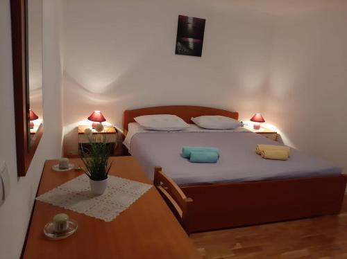 una camera con letto, 2 cuscini e tavolo di Apartmani Marija a Grebaštica
