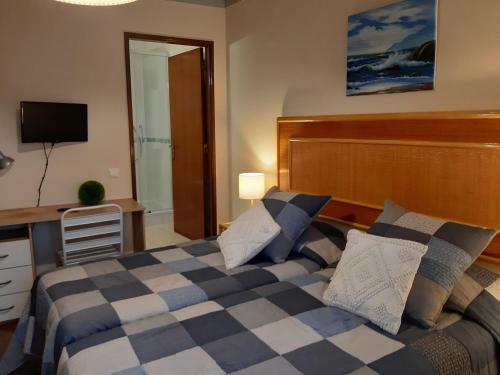 a bedroom with a bed and a desk and a television at Casa Mestre in Vila do Bispo