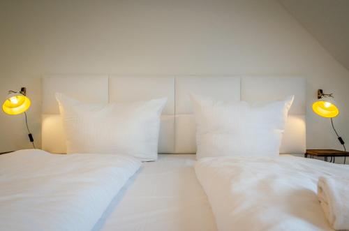 a bedroom with two white pillows and two lamps at MoselUnion - "schlafen & genießen" in Cochem