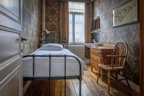 sypialnia z łóżkiem, umywalką i krzesłem w obiekcie Talbot House w mieście Poperinge