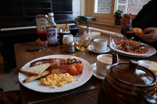 a table with a plate of breakfast food on it at Talbot House in Poperinge
