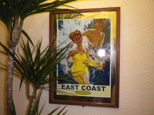 a picture of a woman in a yellow dress on a wall at Balmoral in Skegness