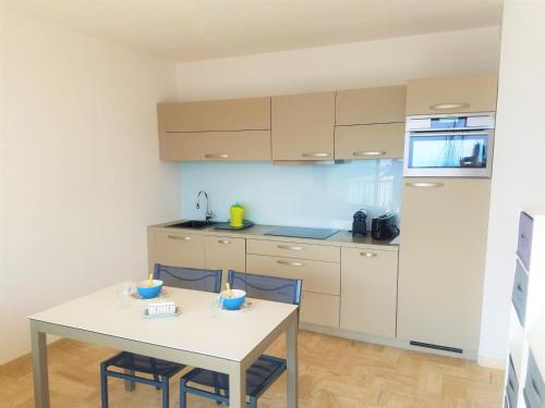 une cuisine avec une table et des chaises dans une pièce dans l'établissement Classé 3 étoiles - Magnifique vue sur le port - Wifi et Clim, à La Grande Motte