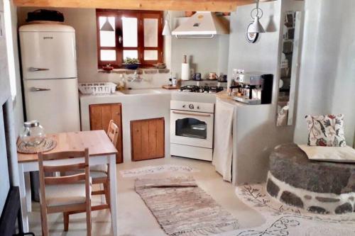 a small kitchen with white appliances and a table at Poseidon House in Mandrakion