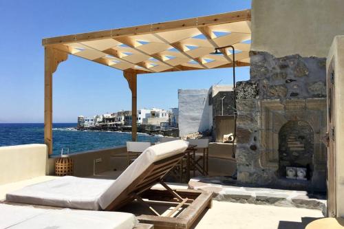 a patio with a chair and an outdoor fireplace at Poseidon House in Mandrakion