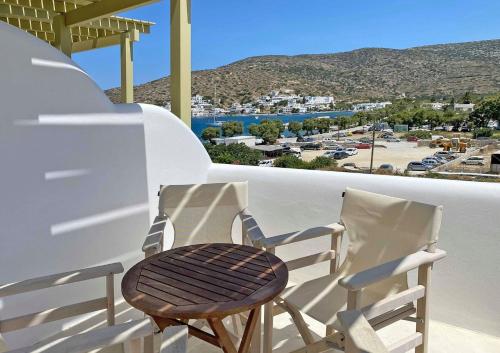 two chairs on a balcony with a view of a town at Diasino Apartments and Car Rental in Katapola