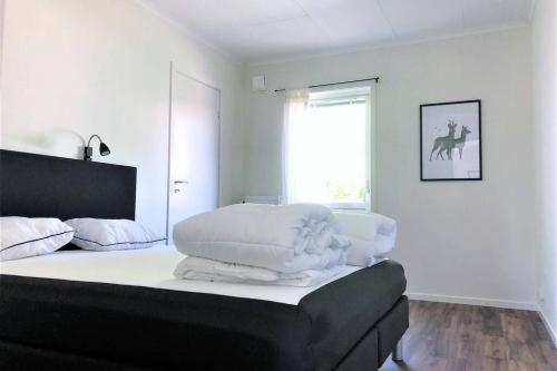Schlafzimmer mit einem Bett mit weißer Bettwäsche und einem Fenster in der Unterkunft Bograngen Lgh C in Brograngen
