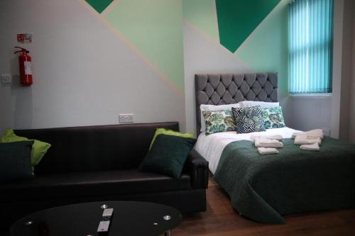 a living room with a bed and a couch at The Rainforest - Central and Cosy in Nottingham