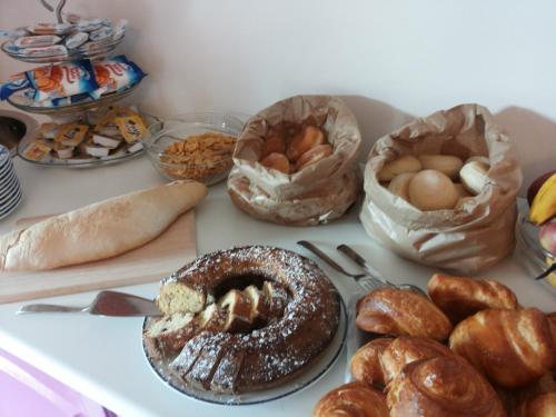 a table topped with lots of different types of bread at B&B Alle Tre Rose in Montignoso