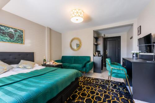 Habitación de hotel con cama y sofá verde en Złota Regalinda & Spa, en Międzyzdroje