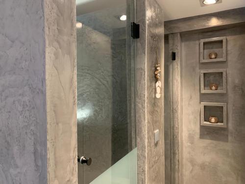 La salle de bains est pourvue d'une douche avec une porte en verre. dans l'établissement Refúgio da Falésia, à Sesimbra