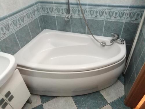 a white toilet in a bathroom with a sink at Apartament MAZURIA in Ełk