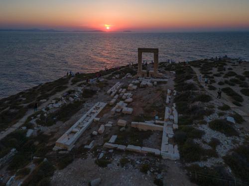 an aerial view of a cemetery in the ocean at sunset at Portara Seaside Luxury Suites in Naxos Chora