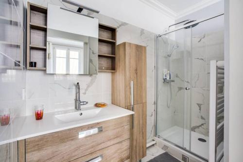 ein Bad mit einem Waschbecken und einer Dusche in der Unterkunft Trocadéro in Paris