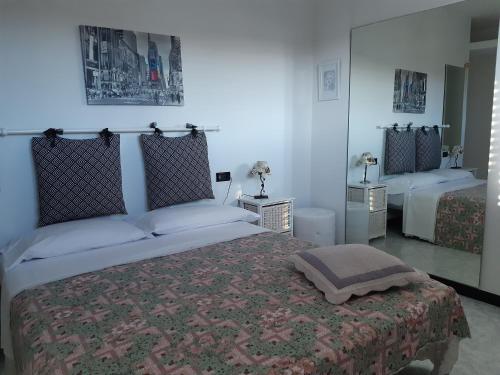 una camera con un grande letto e uno specchio di B&B Villa Grace a Città Sant'Angelo