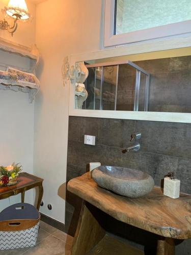 a bathroom with a stone sink on a wooden counter at LE LANTERNE in Villa dʼAlmè