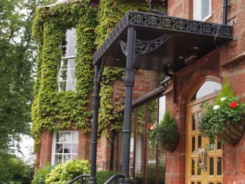 a building with ivy growing on the side of it at Inchture Hotel in Dundee