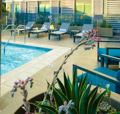 a pool in a building with chairs and a swimming pool at Hotel Mariposa in Los Angeles