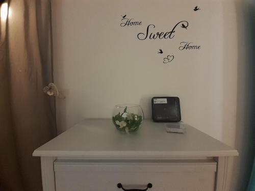 a table with a vase and a clock on a wall at Alloggio Turistico Sutri in Sutri