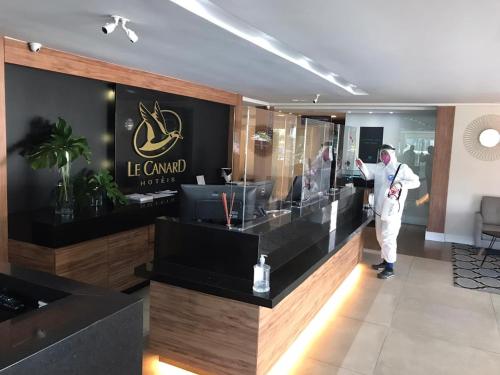 a man standing at a counter in a hotel lobby at Le CanarD Joinville in Joinville