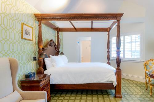卡利斯托加的住宿－柏格森住宿加早餐旅館，一间卧室配有一张天蓬床和一把椅子