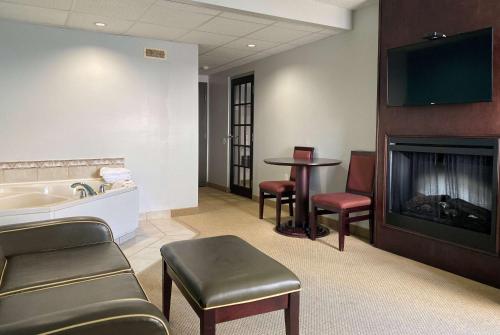 a hospital room with a fireplace and a sink and a table at Travelodge by Wyndham Miramichi New Brunswick in Miramichi