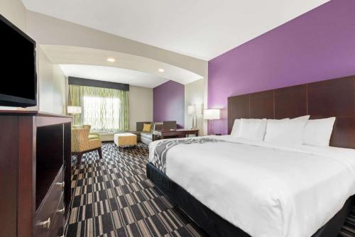 a hotel room with a large bed and a flat screen tv at La Quinta by Wyndham Bridge City-Orange in Bridge City