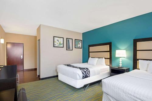 a hotel room with two beds and blue walls at La Quinta Inn & Suites by Wyndham Durant in Durant