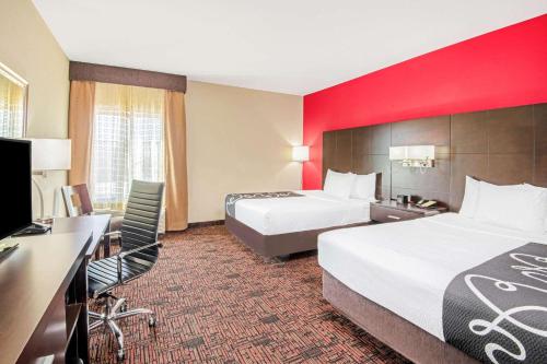 a hotel room with two beds and a desk at La Quinta by Wyndham Elk City in Elk City