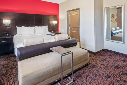 a hotel room with a large bed and a red wall at La Quinta by Wyndham Elk City in Elk City