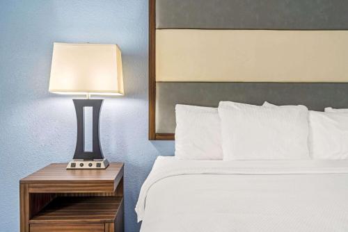a bedroom with a bed and a lamp on a night stand at La Quinta by Wyndham Guthrie in Guthrie