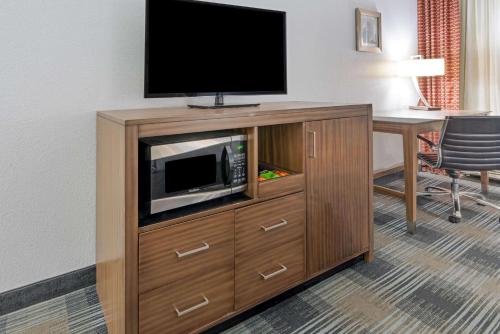 a entertainment center with a flat screen tv in a hotel room at La Quinta by Wyndham Guthrie in Guthrie