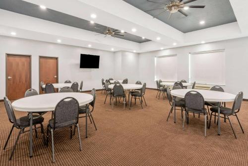 a conference room with tables and chairs and a screen at La Quinta by Wyndham Guthrie in Guthrie