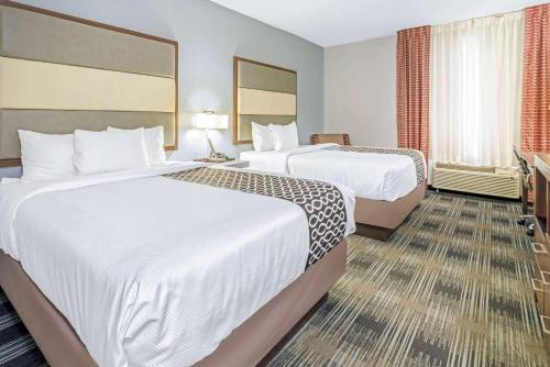 a hotel room with two beds and a television at La Quinta by Wyndham Guthrie in Guthrie