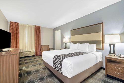 a hotel room with a bed and a flat screen tv at La Quinta by Wyndham Guthrie in Guthrie