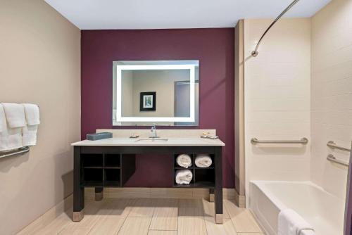 a bathroom with a sink and a tub and a mirror at La Quinta by Wyndham West Monroe in West Monroe