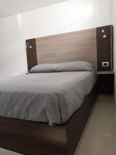 a bed with a wooden headboard in a bedroom at Tepeyac 402 in León