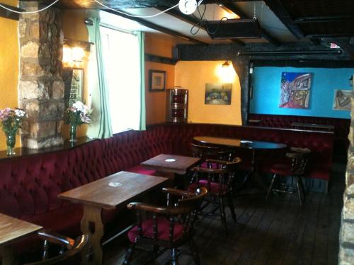 un bar con mesas de madera y sillas en un restaurante en Queen in the West en Lincoln