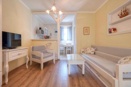 a living room with a couch and a tv at Marinero Apartments in Budva