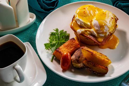 a plate of food with an egg and bread and a cup of coffee at The Sanctuary Hotel Resort Spa in Port Moresby