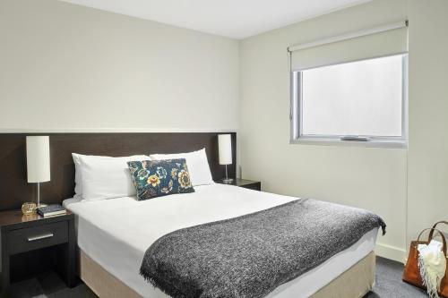 a bedroom with a large bed and a large window at Punthill Essendon in Melbourne