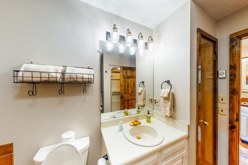 a bathroom with a sink and a toilet and a mirror at Crest 100E in Sugar Mountain