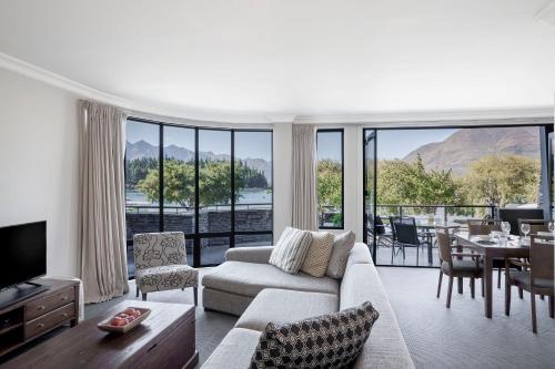 a living room with a couch and a tv and a table at Peppers Beacon in Queenstown