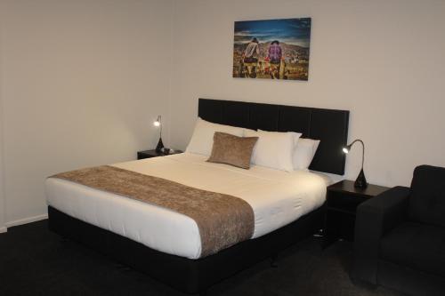 a bedroom with a large bed and a couch at Riverlea Motel in Gore