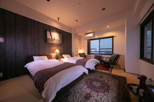 別府市にある国東荘のベッド3台と窓が備わるホテルルームです。