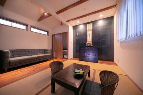 a living room with a couch and a table and chairs at Kunisakisou in Beppu